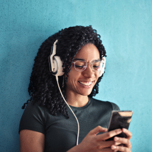 Songwriting: A lady smiling with a phone on her hands and listening to songs with earphones